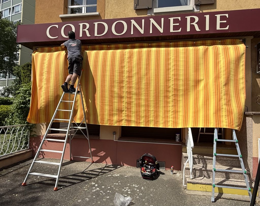 Pose d’une nouvelle toile de store banne à Colmar près de Holtzwihr.