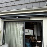 Installation d’un store banne à bras croisés avec lambrequin enroulable à Herrlisheim à côté de Husseren-les-Châteaux.