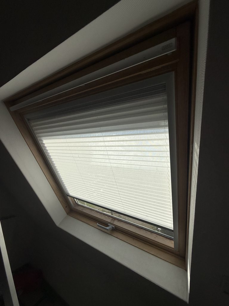 Installation d’un store intérieur plissé filtrant et à enroulement occultant pour une fenêtre de toit Velux à Colmar près de Wintzenheim.