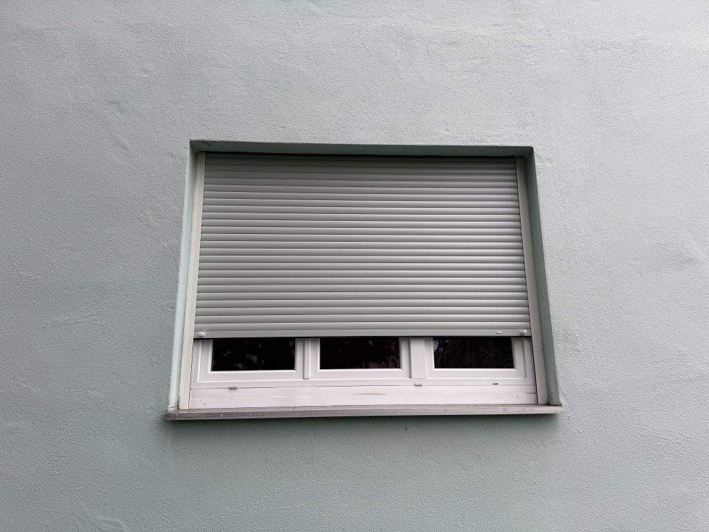 Installation d’un volet roulant à lames en aluminium double paroi et manoeuvre par treuil à Horbourg-Wihr près de Fortschwihr.